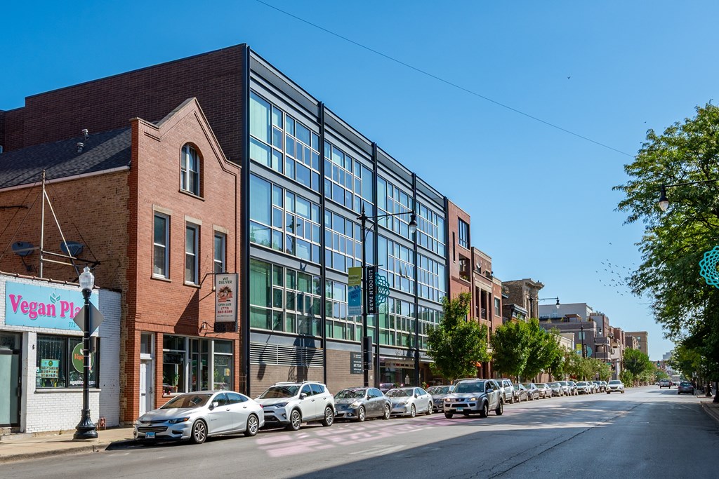 A street view with a vegan pizza shop on the corner.