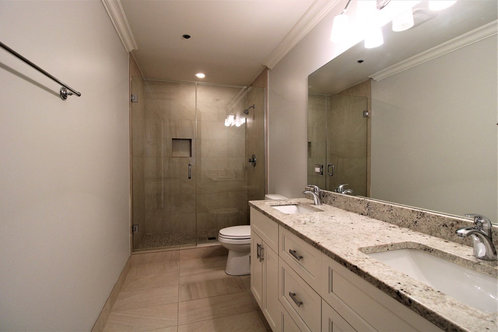 A bathroom with a toilet, sink, and shower.