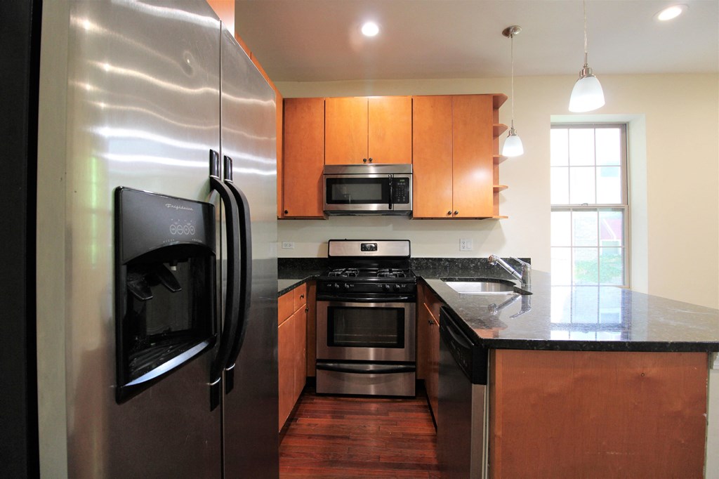 a kitchen with stainless steel appliances and wooden cabinets at Tripp 4321, Chicago, IL