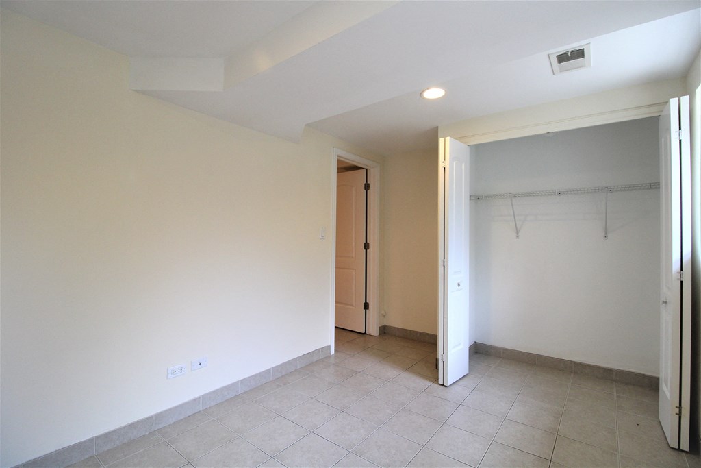 an empty room with a door to a closet and a tiled floor at Tripp 4321, Chicago