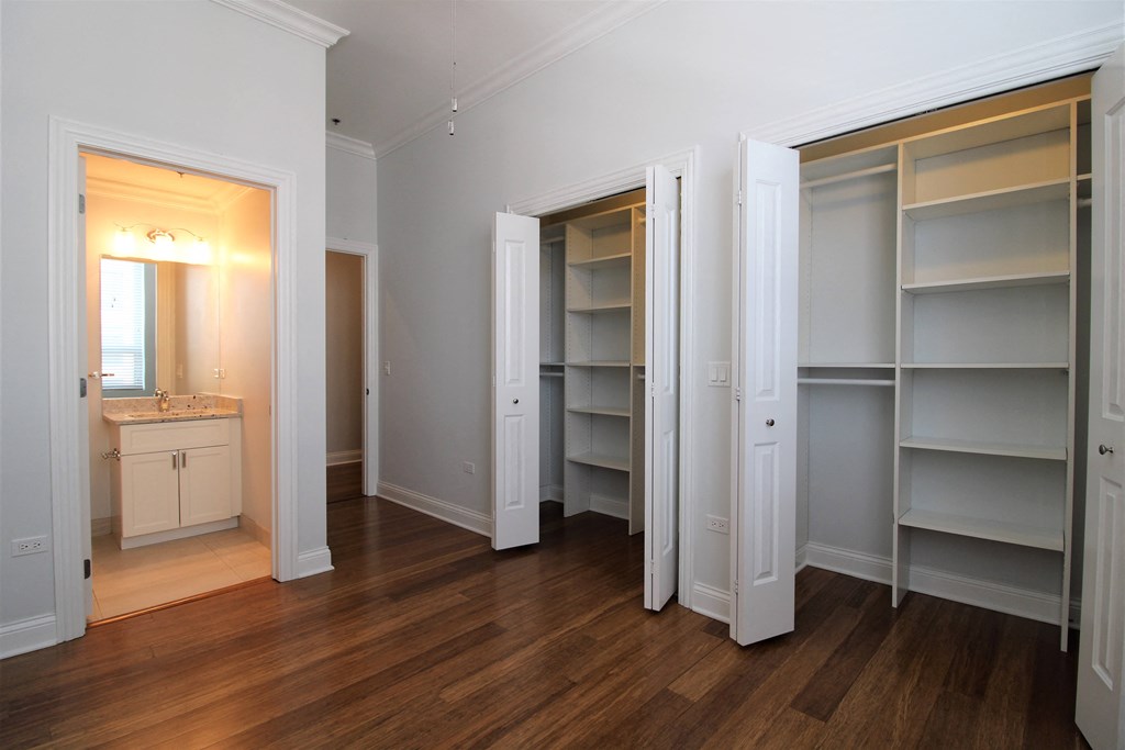 a bedroom with a closet and a sink and a mirror