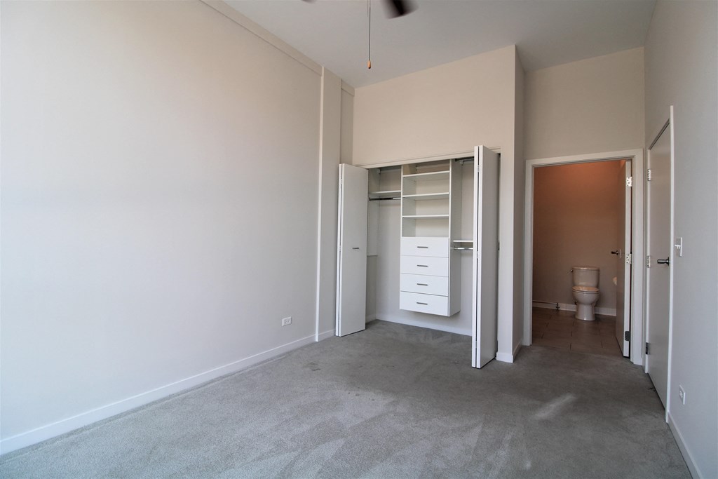 an empty bedroom with a closet and a toilet