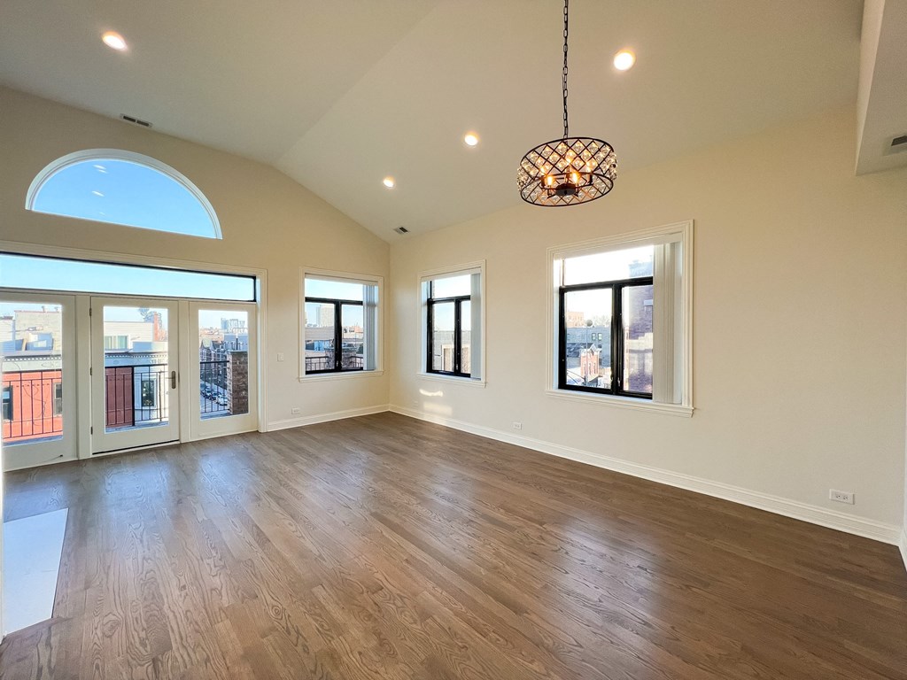 A large, empty room with wooden floors and a skylight.
