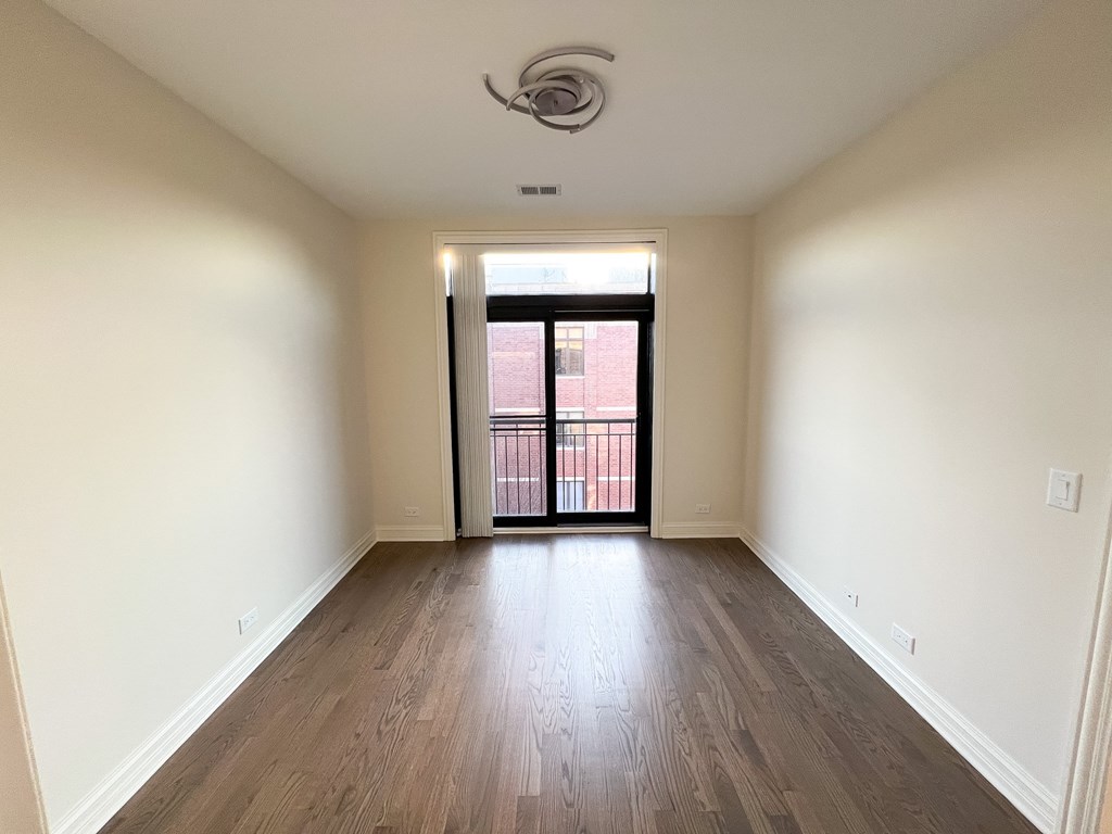 A room with wooden floors and a ceiling fan.