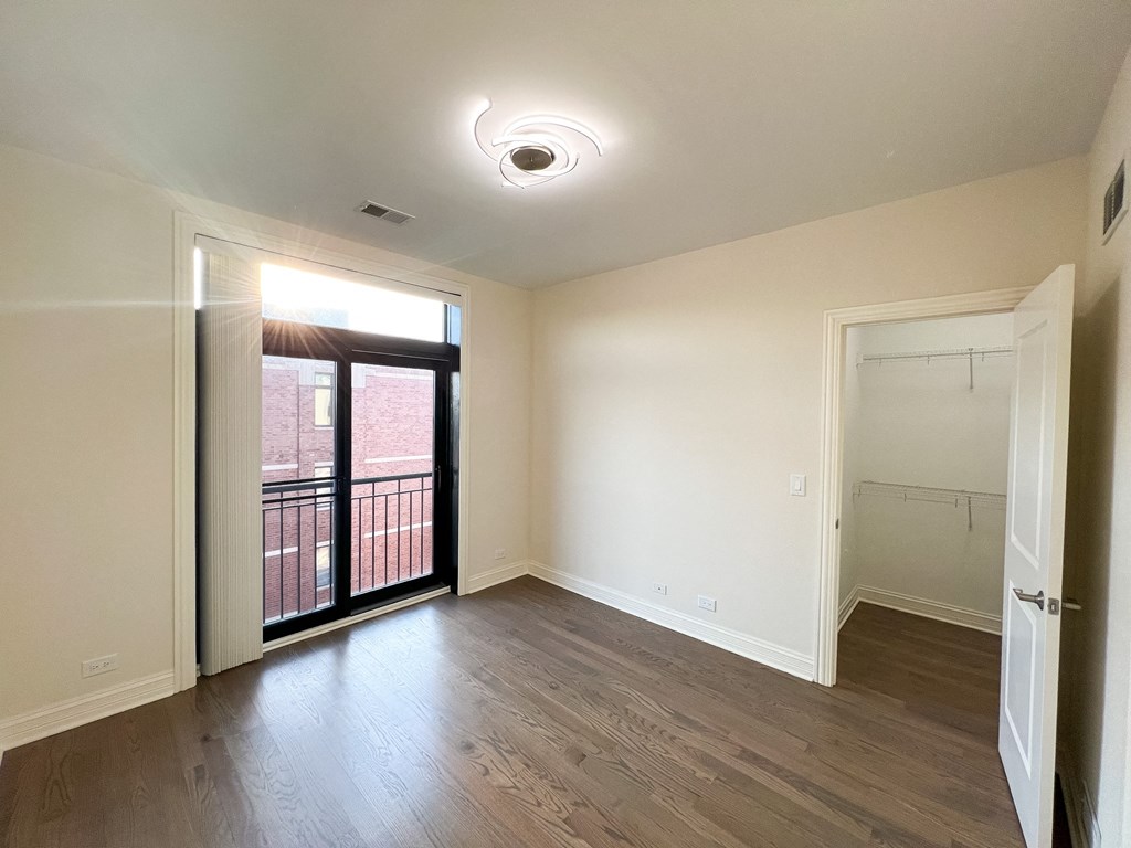 A room with a sliding glass door leading to a balcony.