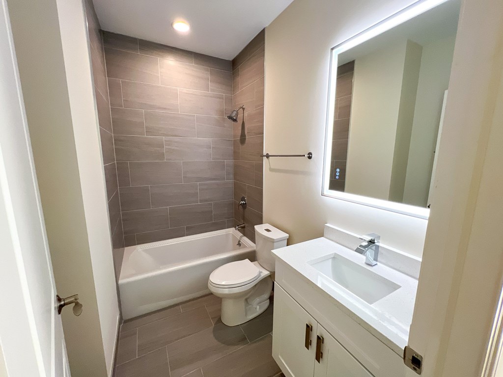 A bathroom with a white toilet, a white sink, and a white bathtub.