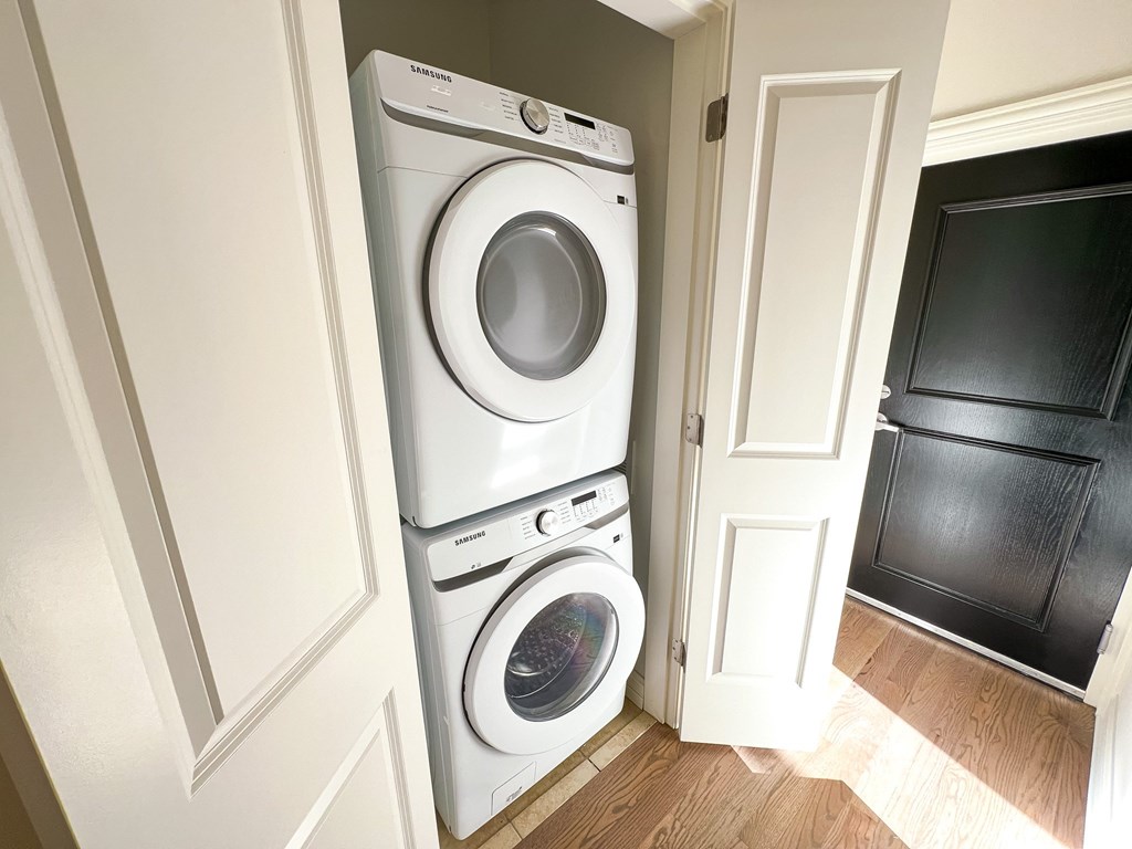 A white Samsung washing machine and dryer in a small laundry room.