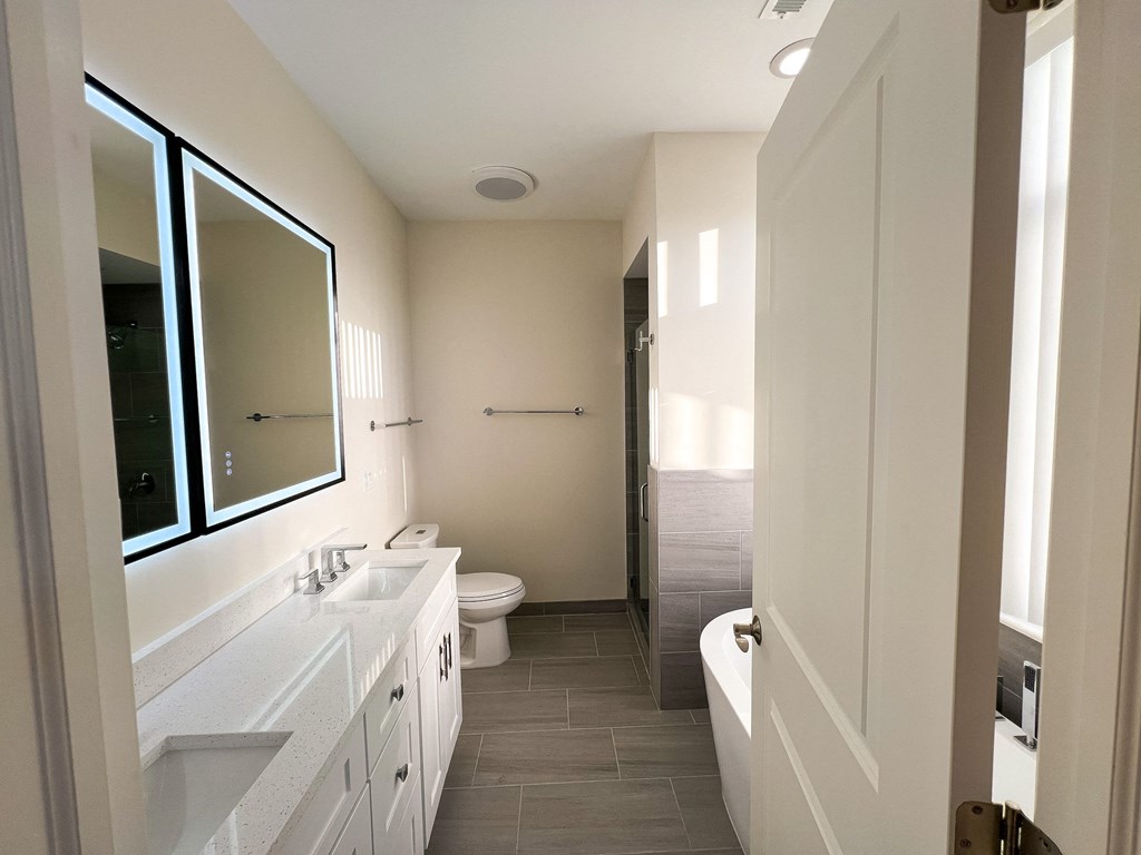 A bathroom with a white vanity and a walk-in shower.