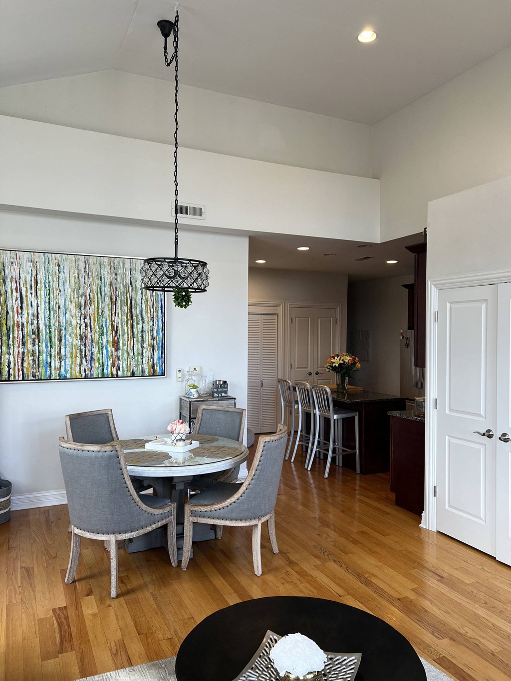 a dining room with a table and chairs and a painting on the wall