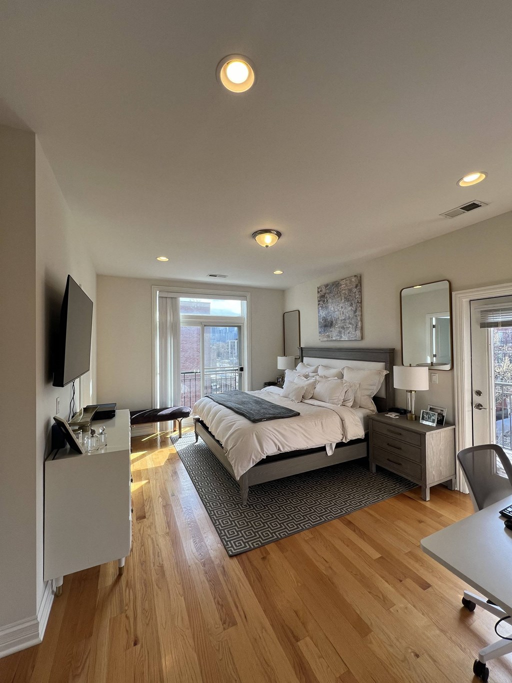 a bedroom with a bed and a desk and a window