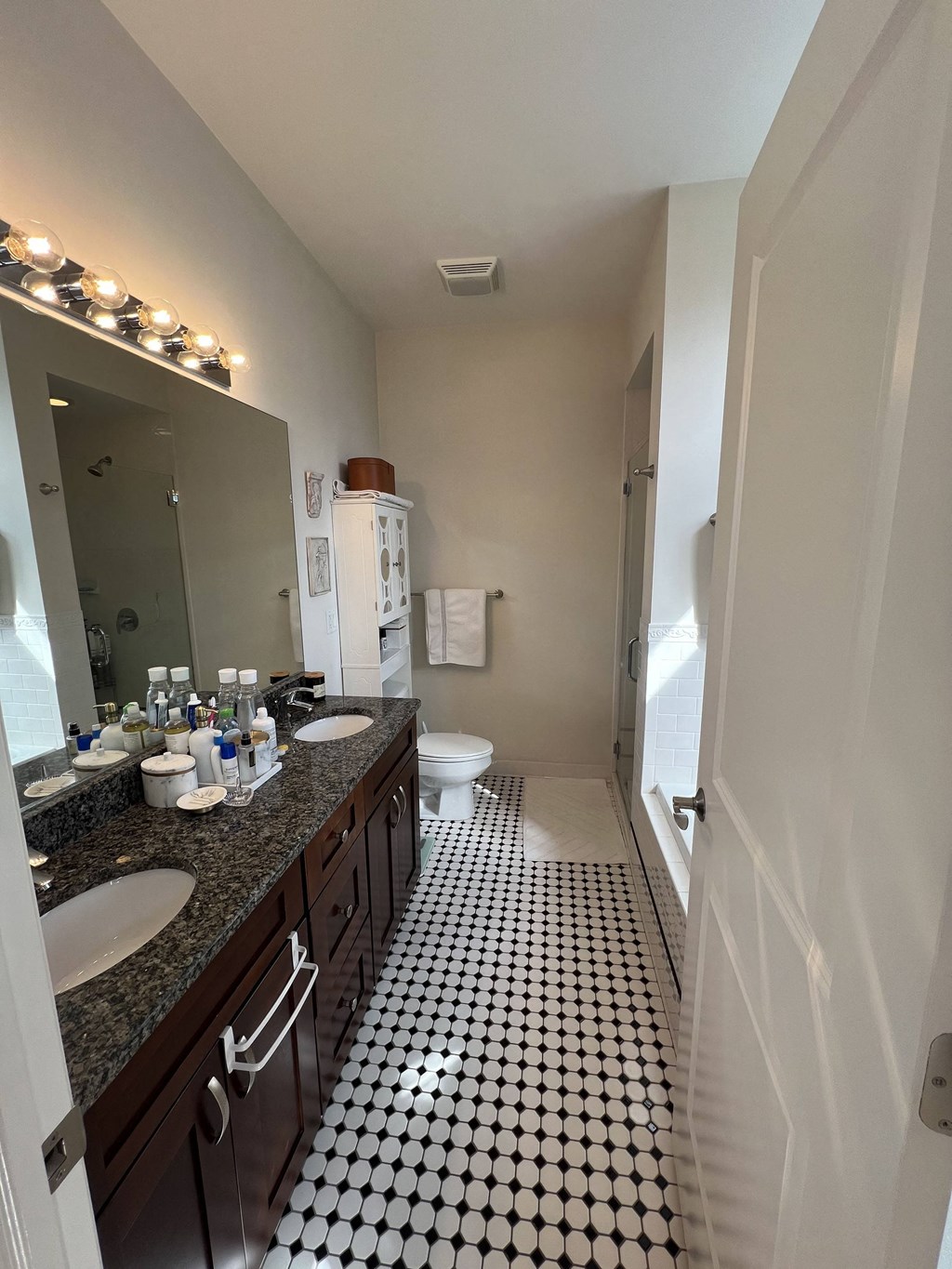 a bathroom with a black and white checkered floor and a toilet