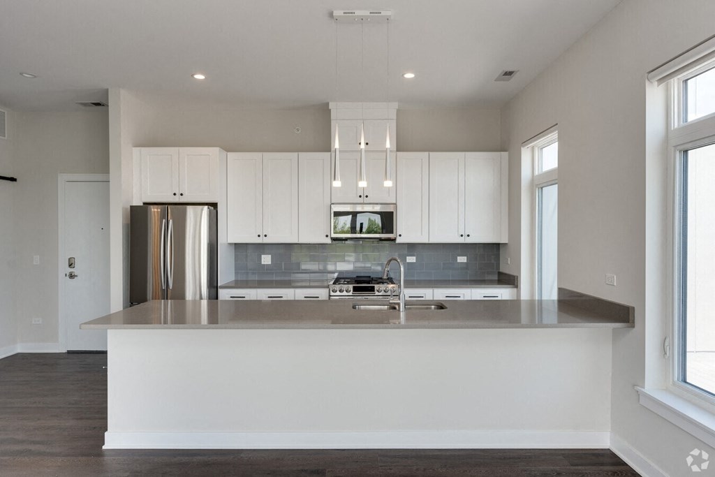 a kitchen with white cabinets and a large counter top