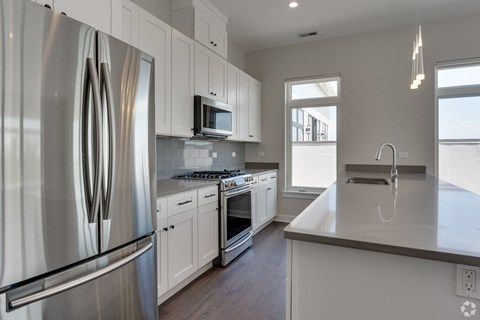 a kitchen with stainless steel appliances and white cabinets