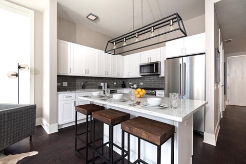 a kitchen with a center island and three stools