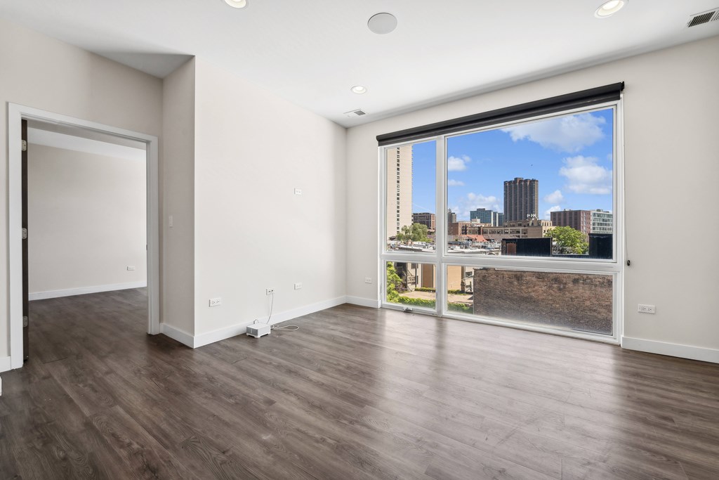 Living room at Highpoint Buena Park on Broadway with modern finishes and a partial view into the bedroom, showcasing open layout design in a Chicago apartment in Buena Park