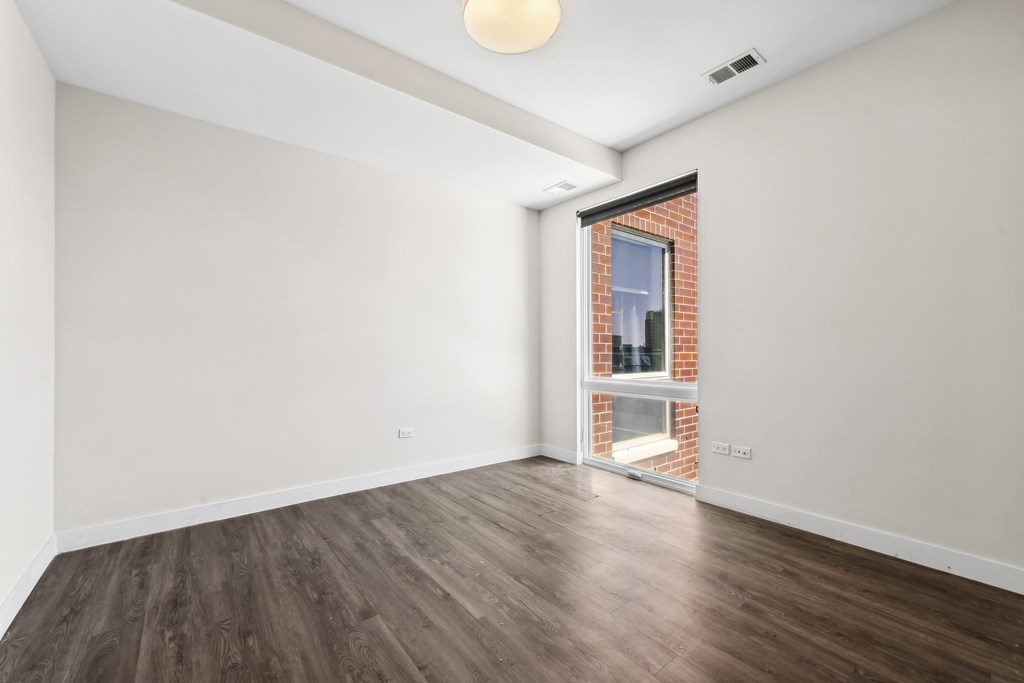 Bedroom at Highpoint Buena Park on Broadway featuring large windows, neutral finishes, and a spacious layout in a modern Buena Park apartment near Montrose Beach in Chicago