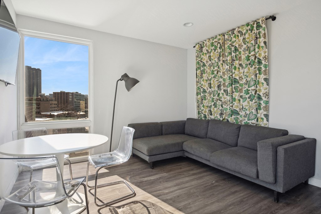 Community living and coworking space at Highpoint Buena Park on Broadway featuring lounge seating, individual workstations, and a mounted TV in a modern resident amenity room in Chicago’s Buena Park neighborhood