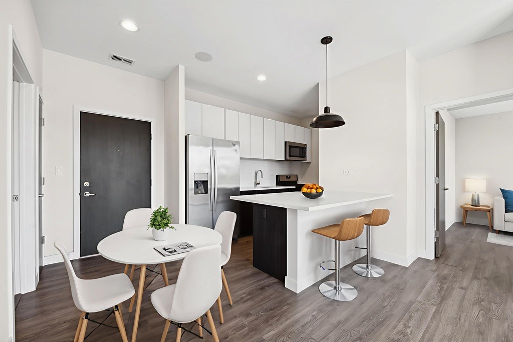 Spacious kitchen at Highpoint Buena Park on Broadway with quartz countertops, stainless steel appliances, and a breakfast bar overlooking an open-concept dining area in a luxury Buena Park apartment near Lake Michigan