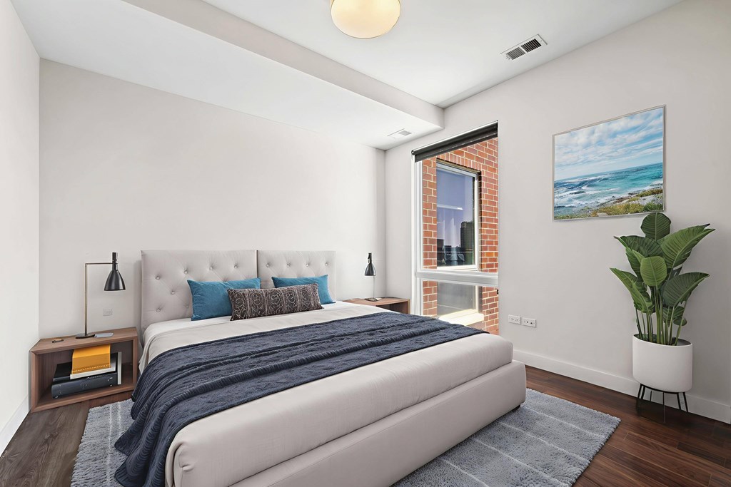 A bedroom with a large bed and a painting on the wall.