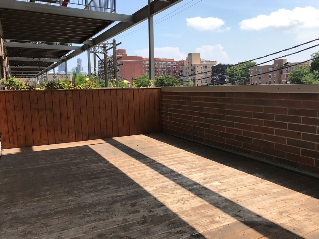 a small patio with a brick wall and a wooden floor