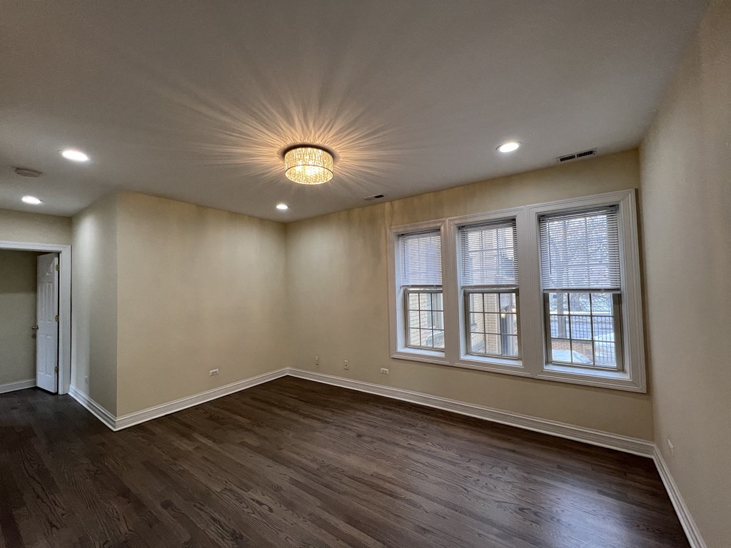 an empty living room with wood floors and windows at Christiana 4954, Chicago, IL