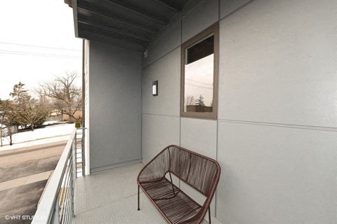 a chair sitting on a balcony next to a building