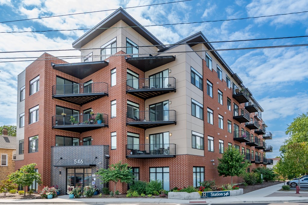 A large red brick building with balconies on the second floor.
