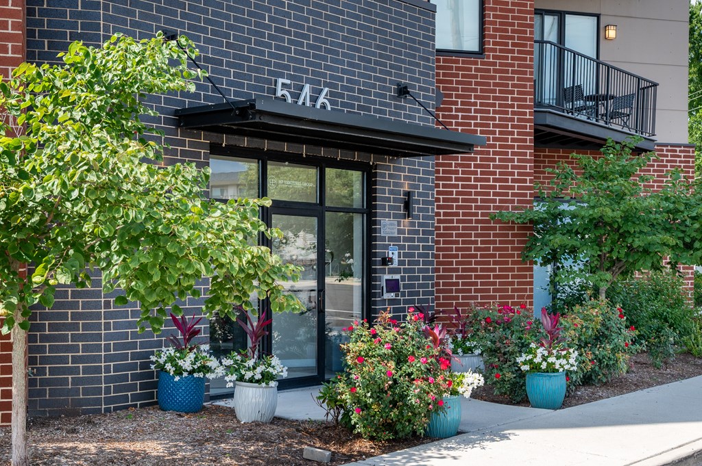 A red brick building with a black awning and a glass door.