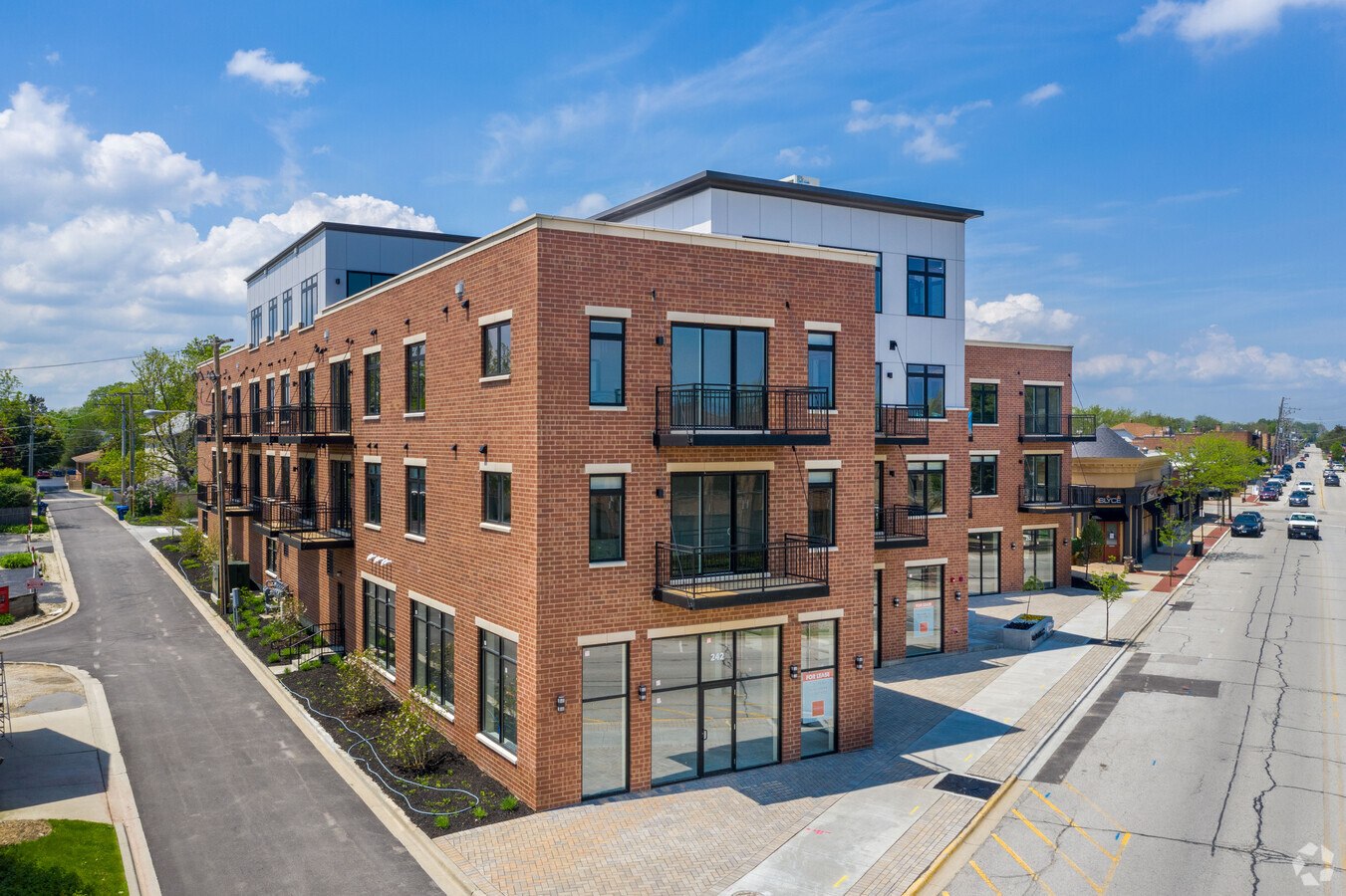 A street view of a row of modern brick apartment buildings.