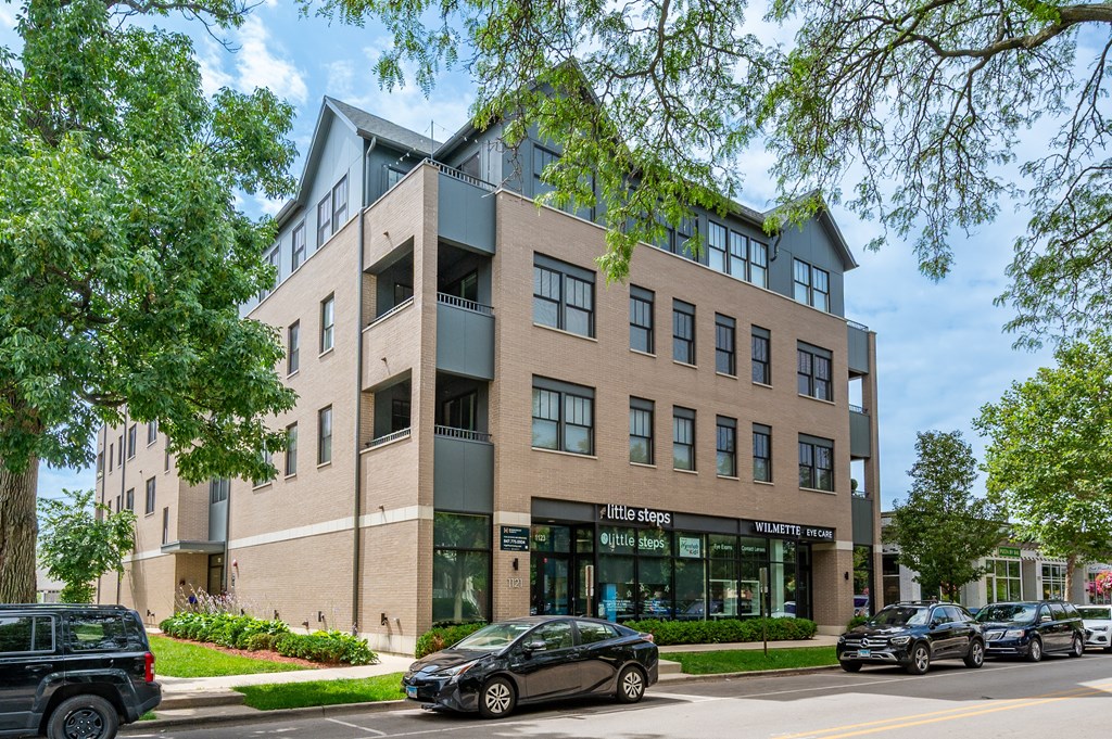 A modern building with a green tree in front.