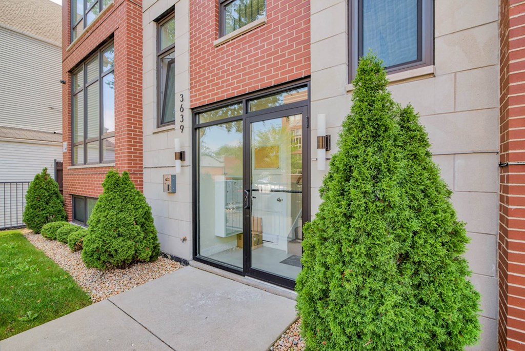 a sidewalk in front of a building with a glass door at Montrose 3634, Chicago