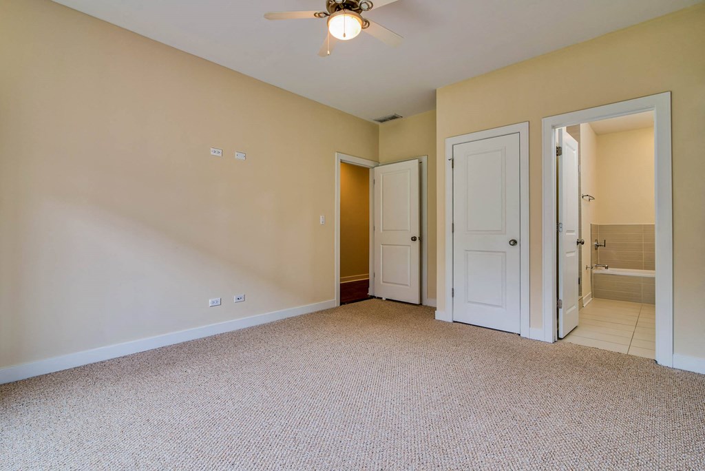 a bedroom with a ceiling fan and a door to a bathroom at Montrose 3634, Illinois