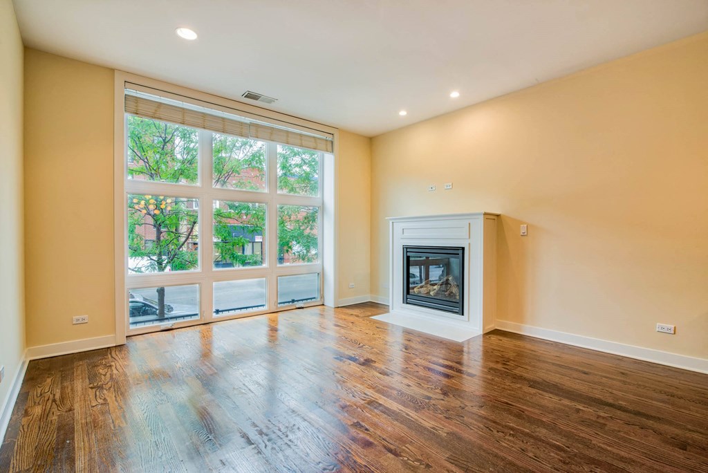 a living room with a fireplace and a large window at Montrose 3634, Illinois, 60618