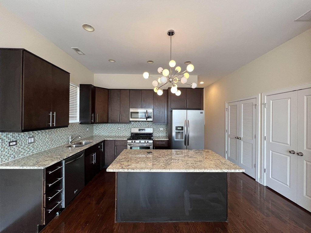 a kitchen with granite counter tops and dark wood cabinets at Montrose 3634, Chicago, IL
