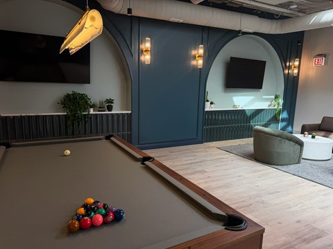 A pool table with a white ball and a rack of multicolored balls.