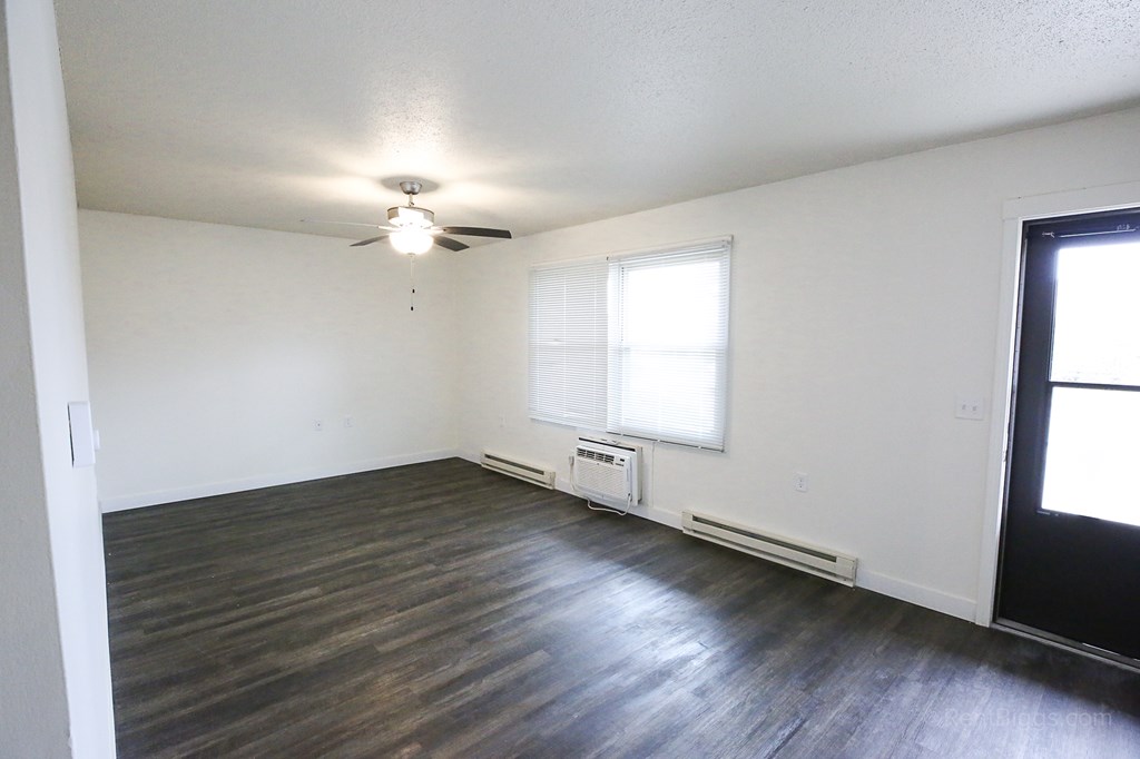 Living Room A room with a ceiling fan and a window with blinds.