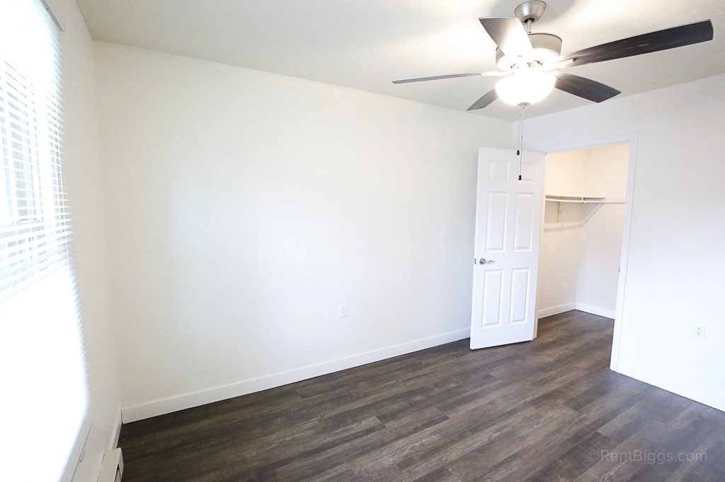 Alternate view of the bedroom A room with a ceiling fan and a door.
