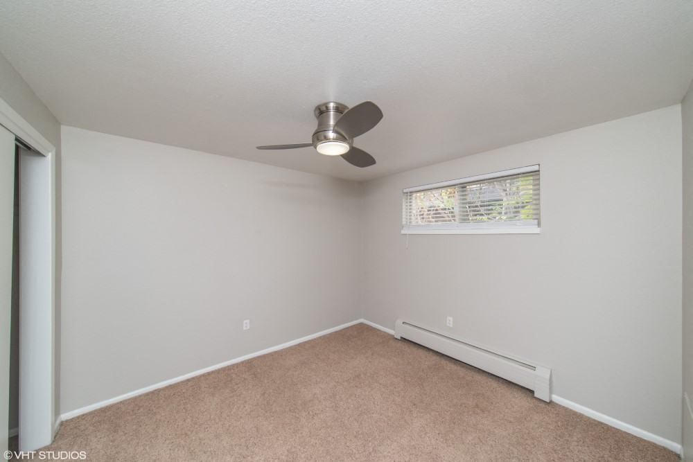 Bedroom with a ceiling fan and plush carpeting