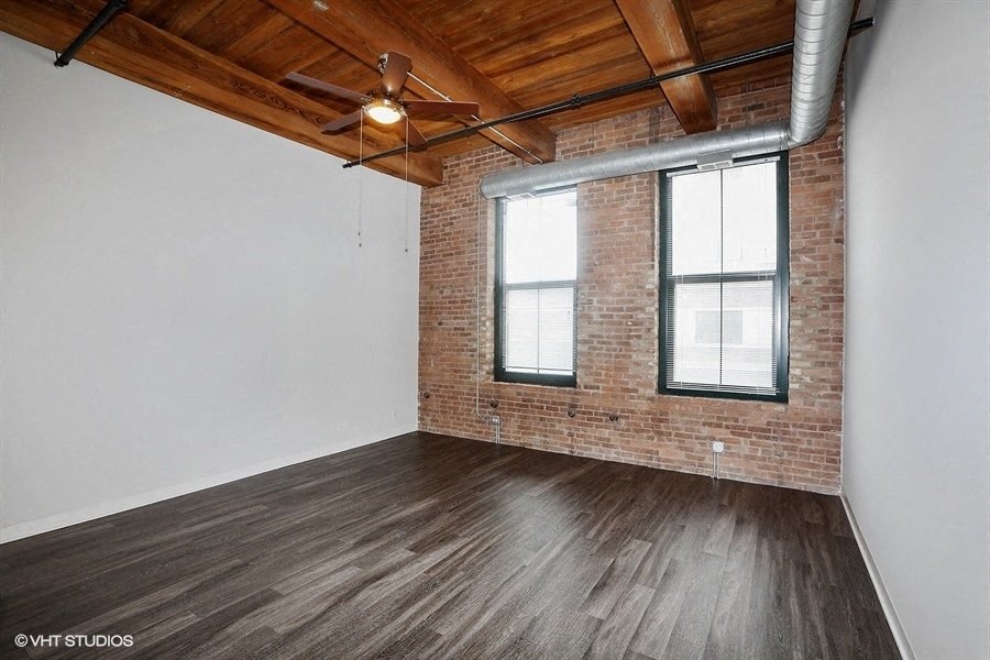 Spacious living area with stunning brick wallsat Carriage House Lofts, Chicago, IL