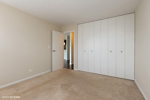 a bedroom with a closet and a door to a hallway