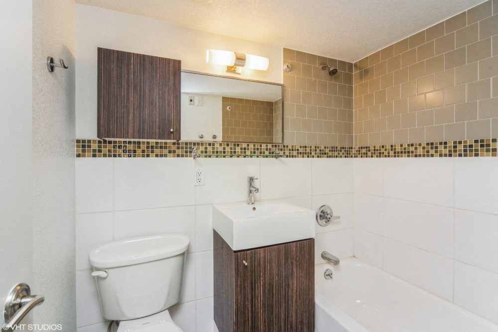 Bathroom with tiled walls and vanity storage
