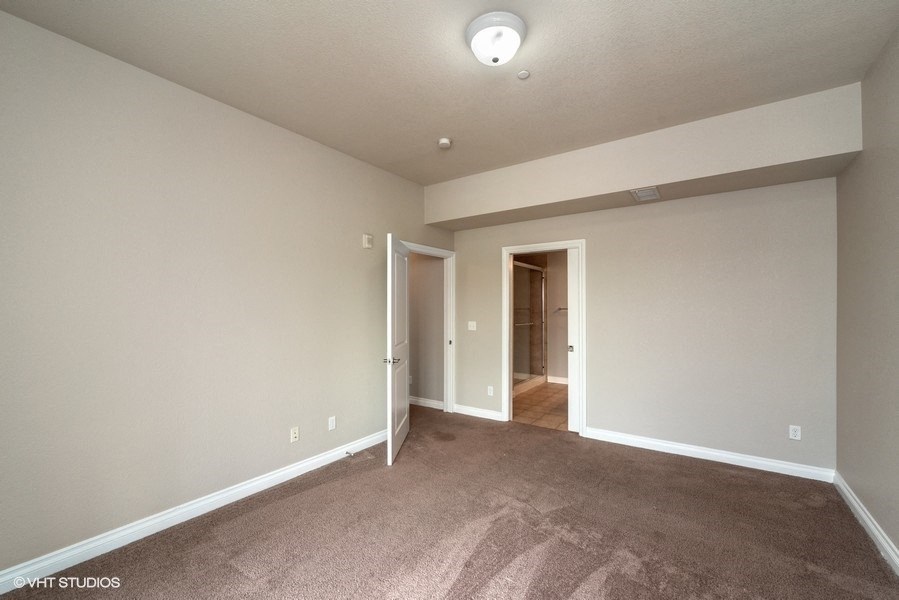 Bedroom with plush carpeting and a private bathroom