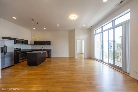 A spacious kitchen with wooden floors and a large island.