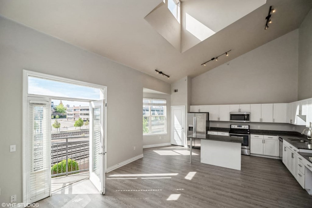 an open kitchen and living room with a large glass door