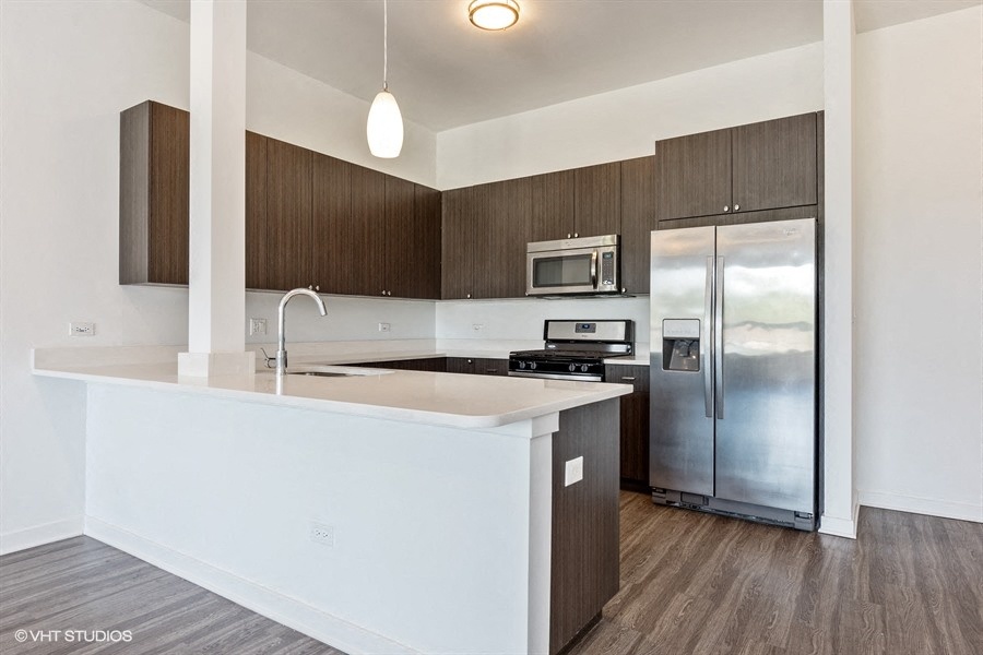 an empty kitchen with a counter top and a refrigerator
