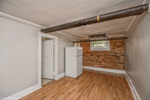 Living area with wood-like flooring and exposed brick wall 1170 N Logan St in Denver, CO