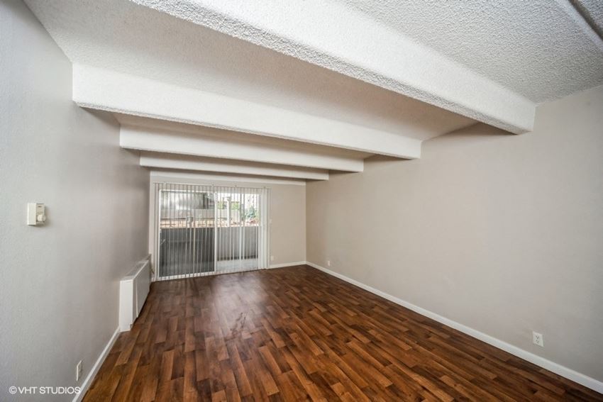 Open and airy living area with chic wood-like flooring Open and airy living area with chic wood-like flooring
