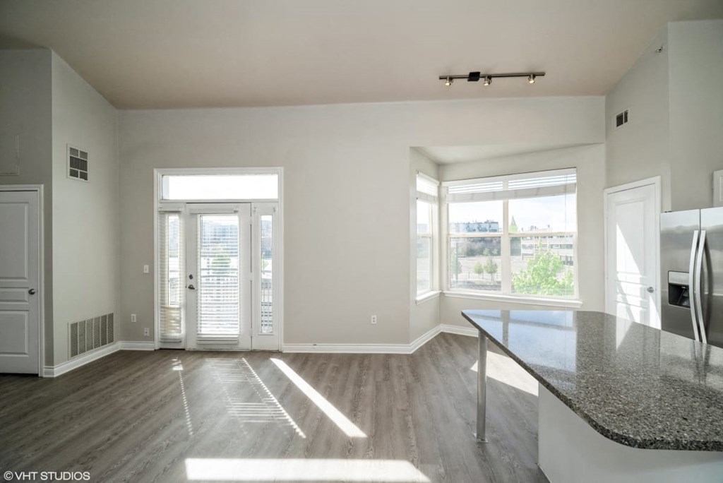 an empty living room with a large window and a table