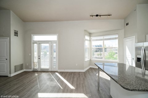 an empty living room with a large window and a table