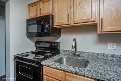 a kitchen with a sink and a stove and a microwave